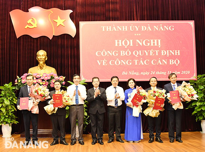 Bí thư Thành ủy Nguyễn Văn Quảng (thứ 4 từ trái sang); Phó Bí thư Thường trực Thành ủy Lương Nguyễn Minh Triết (thứ 4 từ phải sang); Phó Bí thư, Phó Chủ tịch Thường trực UBND thành phố Lê Trung Chinh (thứ 3 từ trái sang) trao các quyết định và tặng hoa chúc mừng tại hội nghị. Ảnh: ĐẶNG NỞ