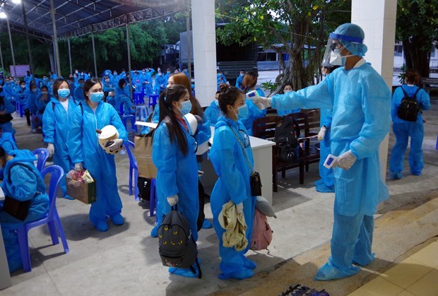 Vietnamese citizens repatriated from abroad have their body temperature checked upon arriving at a quarantine site (Photo: VNA)