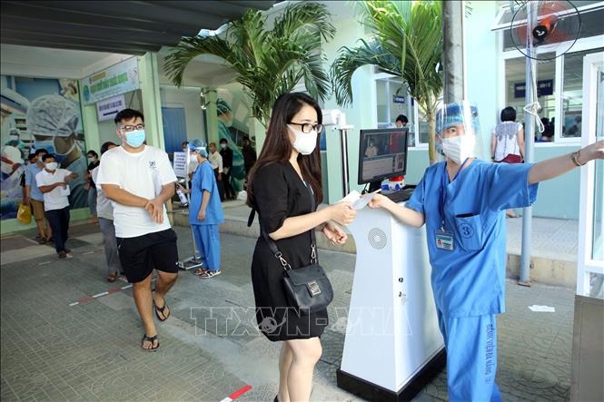 Người dân tuân thủ đeo khẩu trang khi đến các cơ sở y tế. Ảnh: TTXVN