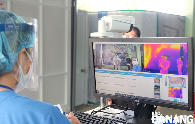Nhân viên y tế Bệnh viện Đà Nẵng kiểm tra thân nhiệt cho bệnh nhân khi vào khám, chữa bệnh. (Ảnh chụp ngày 24-11-2020)Ảnh: PHAN CHUNG	