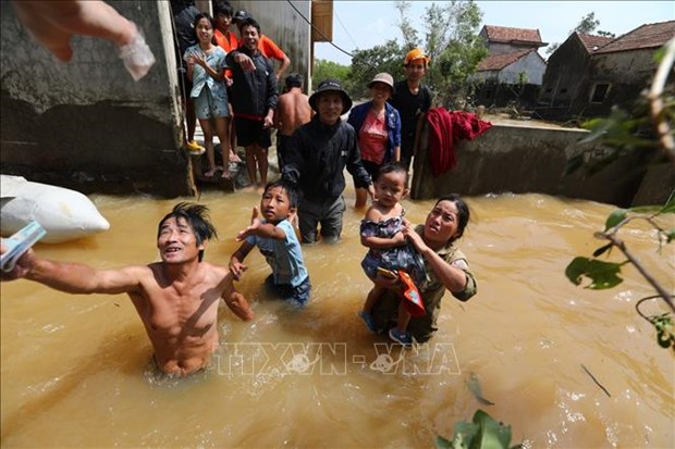 Residents in Le Thuy district of Quang Binh central province receive aid in floodwater (Photo: VNA)
