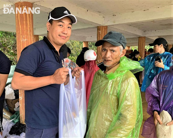 Anh Phạm Quốc Huy (trái) trong một chuyến trao quà cho người dân vùng ngập lụt. Ảnh: H.H