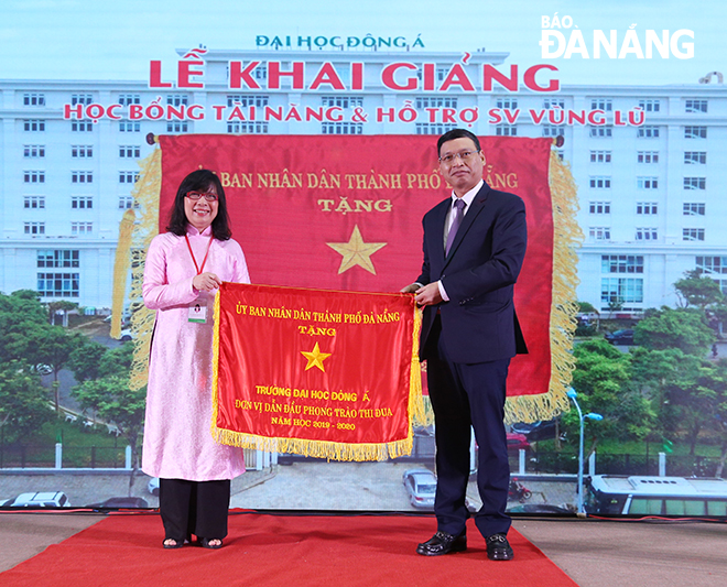 Phó Chủ tịch UBND thành phố Hồ Kỳ Minh trao Cờ thi đua của Chủ tịch UBND thành phố cho Trường Đại học Đông Á. Ảnh: N.P
