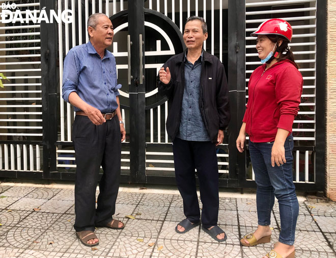 Ông Phạm Văn Mến, Tổ trưởng tổ dân phố số 7 (bìa trái) đến từng nhà để tuyên truyền người dân giữ gìn vệ sinh môi trường, an ninh trật tự.  Ảnh: N.Q	