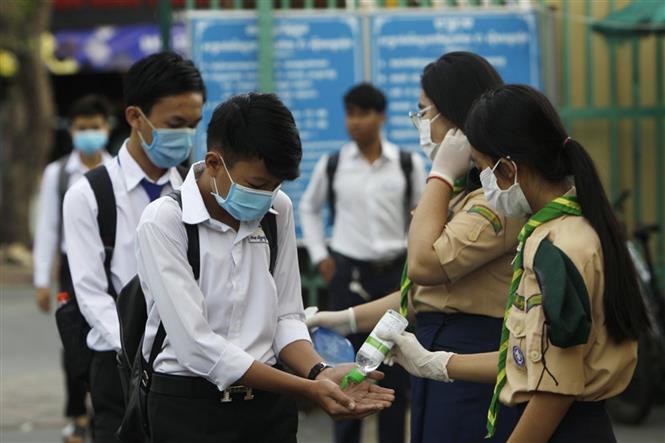 Các học sinh tiến hành sát khuẩn tay nhằm ngăn dịch COVID-19 lây lan, trước khi vào lớp ở Phnom Penh, Campuchia, ngày 2/11/2020. Ảnh: AFP/TTXVN