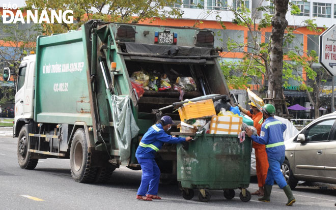Xe “buýt” rác đang thu gom, vận chuyển rác tại điểm tập kết tạm trên tuyến đường Hàm Nghi, xóa bỏ điểm tập kết thùng rác lớn ở tuyến đường Tản Đà, quận Thanh Khê. Ảnh: HOÀNG HIỆP