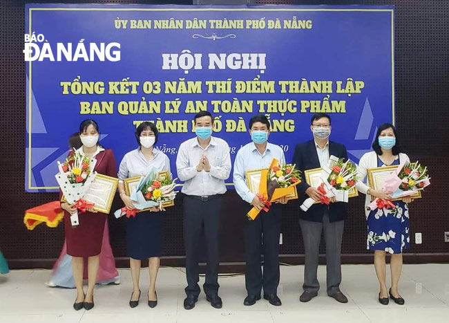 Phó Chủ tịch Thường trực UBND thành phố Lê Trung Chinh tặng Bằng khen cho các cá nhân. Ảnh: PHAN CHUNG