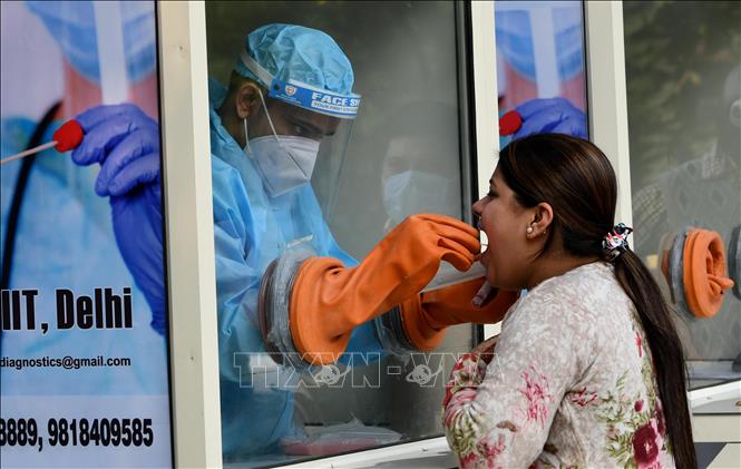 Nhân viên y tế lấy mẫu dịch xét nghiệm COVID-19 cho người dân tại New Delhi, Ấn Độ, ngày 6/11. Ảnh: THX/TTXVN