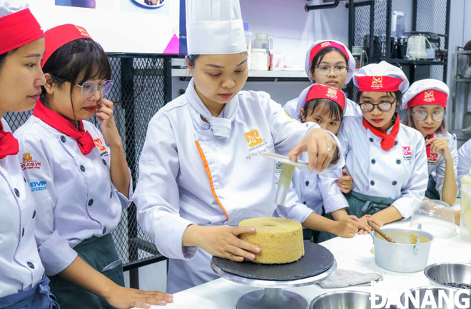 Trainees of the Da Nang branch of the A-Au (Asia-Europe) Vocational Guidance JSC learning how to make birthday cakes 