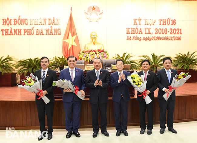 Head of the Da Nang National Assembly Truong Quang Nghia (3rd left) and municipal Party Committee Secretary Nguyen Van Quang (3rd right) presenting flowers to Mr Nguyen Nho Trung (2nd right), Huynh Duc Tho (2nd left), newly-appointed People’s Council Chairman Luong Nguyen Minh Triet (1st right), and freshly-appointed People’s Committee Le Trung Chinh (1st left) 