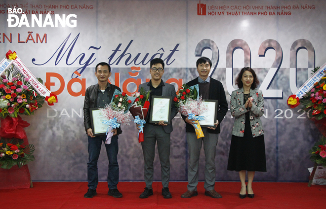 Phó Giám đốc Sở Văn hóa và Thể thao Nguyễn Thị Hội An (bìa phải) trao giải Nhì (không có giải Nhất) cho các họa sĩ có tác phẩm mỹ thuật tiêu biểu, xuất sắc trong năm 2020. Ảnh: XUÂN DŨNG