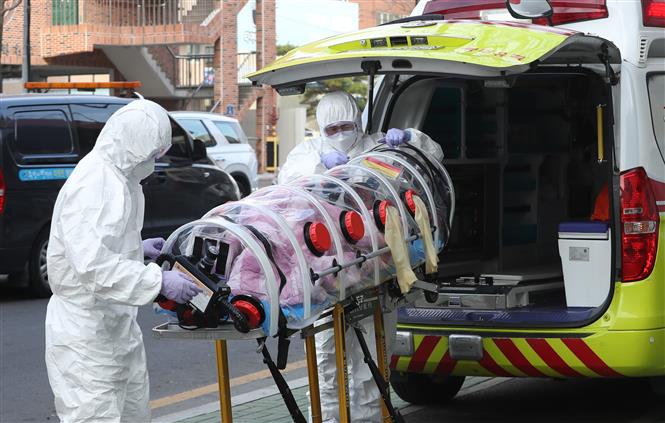 Nhân viên y tế chuyển bệnh nhân mắc Covid-19 lên xe cứu thương tại thành phố Ulsan, Hàn Quốc ngày 7-12-2020. Ảnh: Yonhap/TTXVN