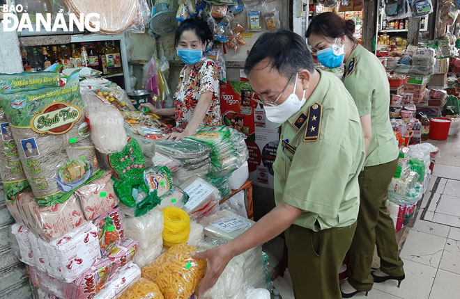 Inspectors from the Da Nang Market Management Bureau making a surprise inspection visit to the Dong Da Market in an attempt to prevent the trading of fake, counterfeit, illegally smuggled, and poor-quality goods at this venue. 