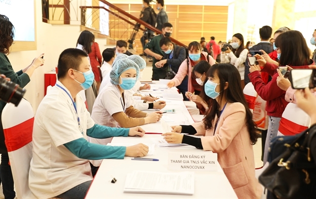 Medical workers provide information to volunteers on the first phase of human trials of a Covid-19 vaccine in Ha Noi on Thursday.