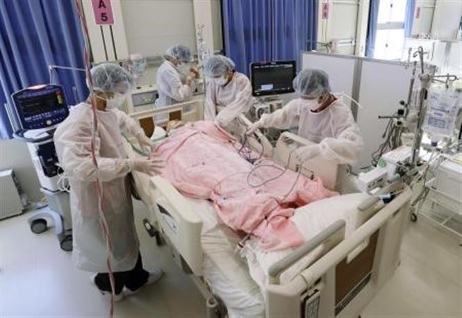 Nhân viên y tế điều trị cho bệnh nhân Covid-19 tại bệnh viện dã chiến ở Osaka, Nhật Bản, ngày 11/12/2020. Ảnh: Kyodo/ TTXVN