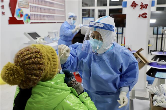 Nhân viên y tế lấy mẫu dịch xét nghiệm Covid-19 cho người dân tại thành phố Tuy Phân Hà, tỉnh Hắc Long Giang, Trung Quốc ngày 10/12/2020. Ảnh: THX/ TTXVN