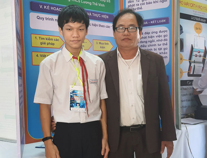 Trần Quang Minh (trái) với dự án “Thiết bị cảnh báo chống gù lưng” xuất sắc đoạt giải Nhất tại Cuộc thi khoa học kỹ thuật quận Liên Chiểu năm học 2020-2021. (Ảnh nhân vật cung cấp)