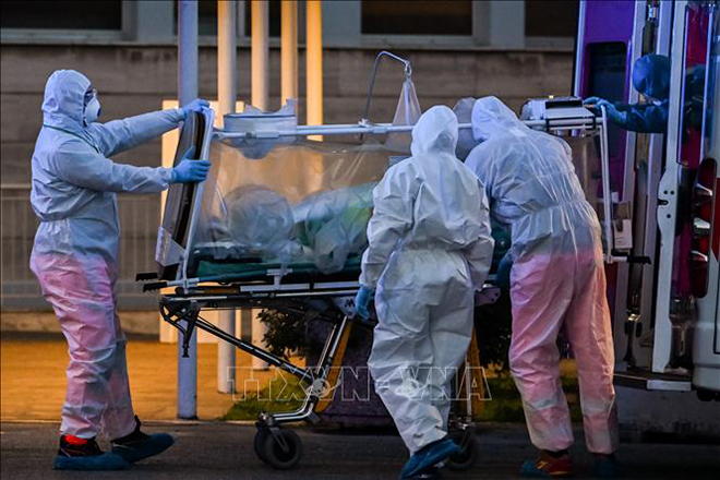  Nhân viên y tế chuyển bệnh nhân nhiễm Covid-19 tới bệnh viện ở Rome, Italy. Ảnh: AFP/TTXVN