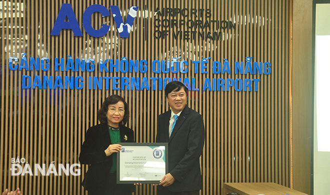 Giám đốc Sở Y tế Ngô Thị Kim Yến trao chứng nhận cho lãnh đạo Cảng Hàng không quốc tế Đà Nẵng. Ảnh : THÀNH LÂN