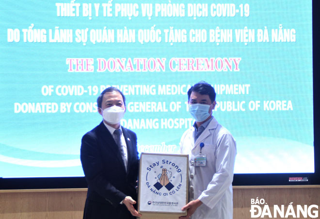 Bác sĩ Lê Đức Nhân, Giám đốc Bệnh viện Đà Nẵng (phải) tiếp nhận thiết bị y tế do Tổng lãnh sự Hàn Quốc tại Đà Nẵng Ahn Min Sik trao tặng. Ảnh: H.H
