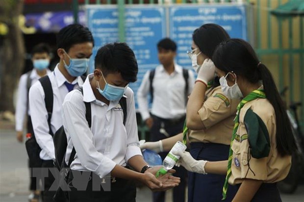 Học sinh Campuchia khử trùng tay trước khi vào lớp. Ảnh: AFP/TTXVN