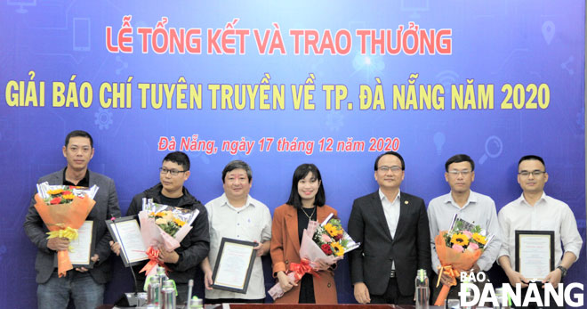Trưởng ban Tuyên giáo Thành ủy Nguyễn Đình Vĩnh (thứ 3, phải sang) trao giải cho các tác giả có tác phẩm đoạt giải ở nhóm đề tài tuyên truyền chủ đề “Năm tiếp tục đẩy mạnh thu hút đầu tư”. Ảnh: LAM PHƯƠNG	