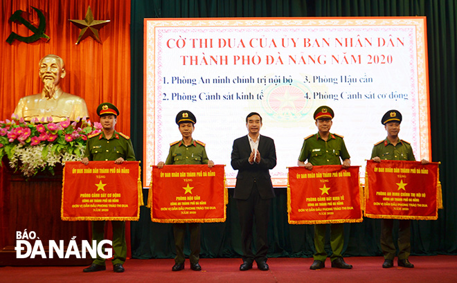 Chủ tịch UBND thành phố Lê Trung Chinh (giữa) trao Cờ thi đua cho các tập thể. Ảnh: NGỌC PHÚ