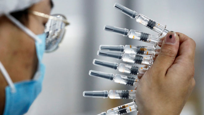 Một nhân viên đang kiểm tra chất lượng tại cơ sở đóng gói vắc-xin của hãng Sinovac  ở Bắc Kinh, Trung Quốc. Ảnh: Reuters