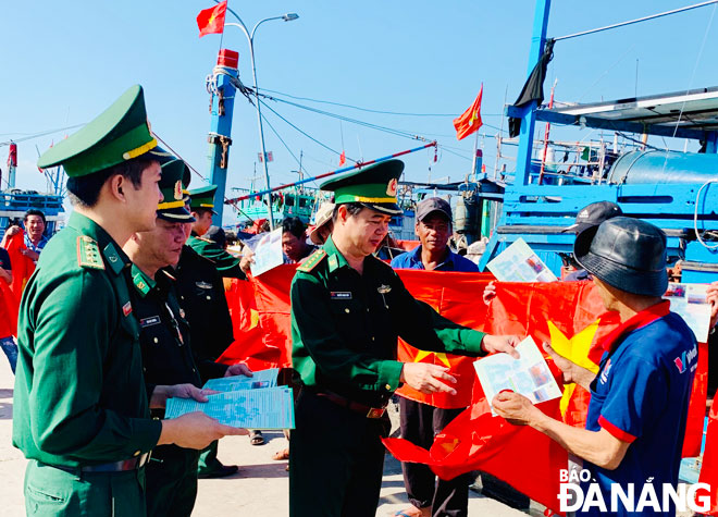 Bộ đội Biên phòng thành phố trao cờ Tổ quốc và kết hợp tuyên truyền bảo vệ chủ quyền biển, đảo cho ngư dân.Ảnh: PHAN HOÀNG HIỆP