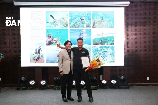 Director of the municipal Department of Natural Resources and Environment To Van Hung (left) and the first prize winner Dao Dang Cong Trung