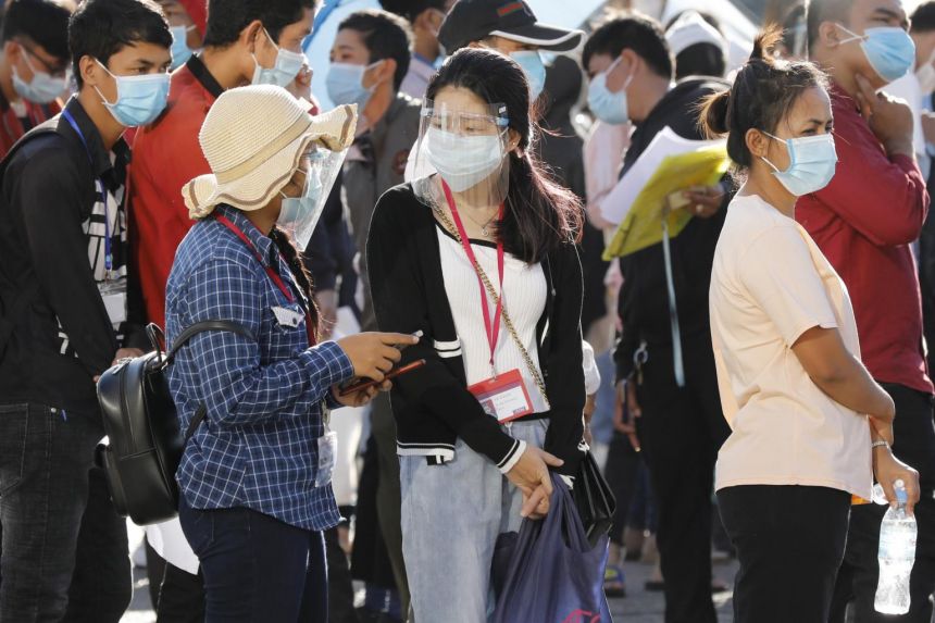 Người dân Campuchia đeo khẩu trang và kính chắn phòng dịch. Ảnh: Straits Times