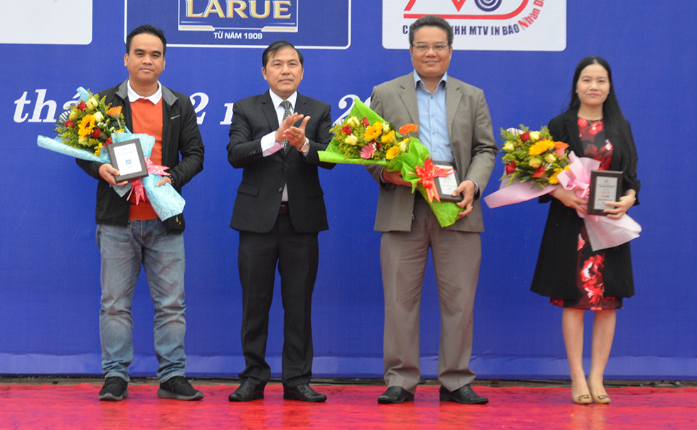 Mr Nguyen Duc Nam (2nd, left) presenting flowers and medals to sponsors