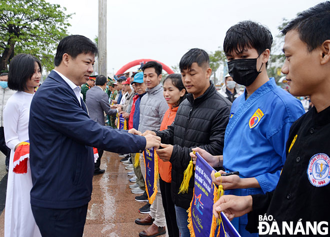 Phó Bí thư Thường trực Thành ủy, Chủ tịch HĐND thành phố Lương Nguyễn Minh Triết tặng cờ lưu niệm cho các đoàn vận động viên. Ảnh: NGỌC PHÚ