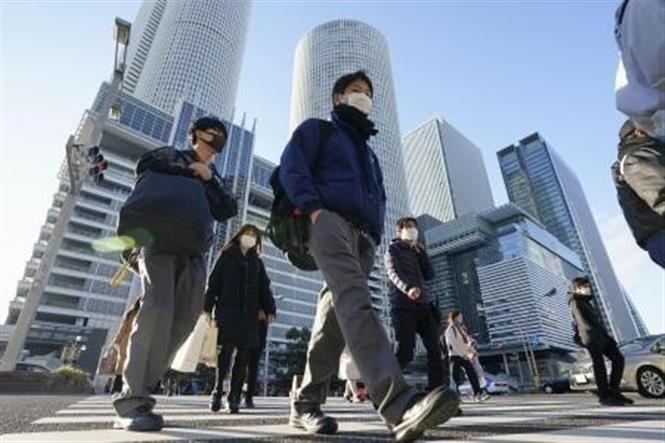 Người dân di chuyển trên đường phố tại Tokyo, Nhật Bản, ngày 21-12-2020. Ảnh: Kyodo/ TTXVN