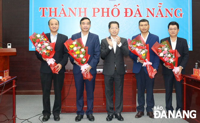 Bí thu Thành ủy Nguyễn Văn Quảng (đứng giữa) tặng hoa chúc mừng đồng chí trong Ban cán sự Đảng UBND thành phố. Ảnh: TRỌNG HÙNG