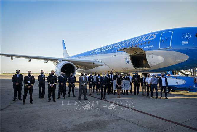 Nhà chức trách cùng phi hành đoàn chụp ảnh lưu niệm bên máy bay thuộc hãng hàng không quốc gia Aerolineas Argentinas của Argentina tại sân bay quốc tế Sheremetyevo, gần Moskva, Nga trước khi máy bay này chở lô vaccine Sputnik V ngừa bệnh COVID-19 đầu tiên về nước ngày 23/12. Ảnh: AFP/TTXVN