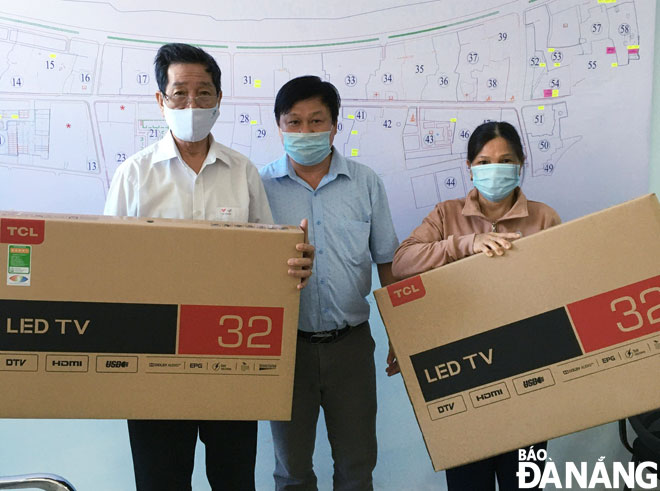 Phó Chủ tịch UBND phường Xuân Hà Nguyễn Văn Tâm (giữa) tặng tivi cho hai gia đình chính sách được hỗ trợ kinh phí sửa nhà trong năm 2020. Ảnh: THANH VÂN