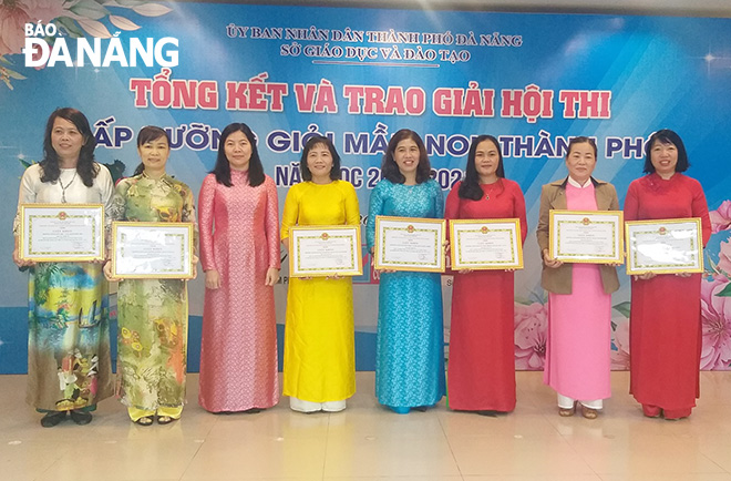 Giám đốc Sở GD&ĐT thành phố Lê Thị Bích Thuận (thứ 3 từ trái sang) trao giải xuất sắc cho 7 tập thể. Ảnh: NGỌC PHÚ