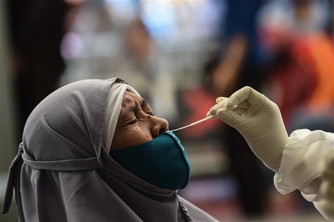 Nhân viên y tế lấy mẫu xét nghiệm COVID-19 cho người dân tại Jakarta, Indonesia ngày 22/12/2020. Ảnh: THX/TTXVN