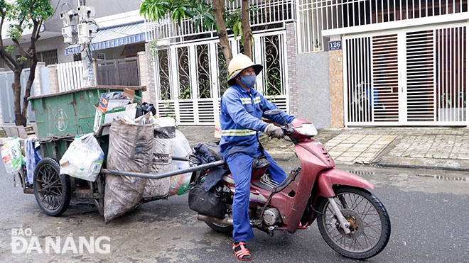 Anh Nguyễn Minh gắn bó với công việc thu gom rác đã 7 năm nay. Ảnh: MAI HIỀN