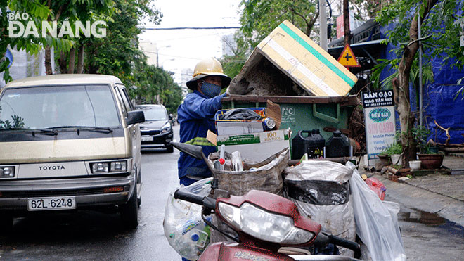 Anh Nguyễn Minh đang thu gom rác. Ảnh: MAI HIỀN