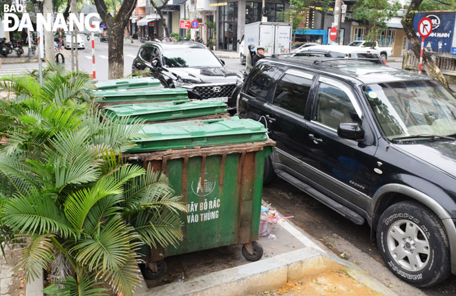 Vịnh tập kết thùng rác trên tuyến đường Thái Phiên bị ô-tô đỗ che chắn vào sáng 13-12. Ảnh: HOÀNG HIỆP	