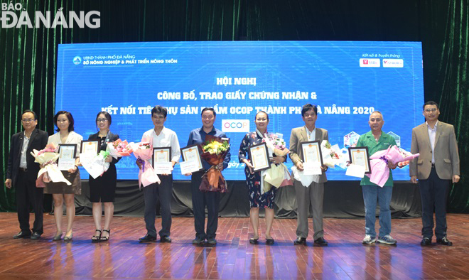 Phó Chủ tịch Thường trực UBND thành phố Hồ Kỳ Minh (bìa phải) trao chứng nhận cho các chủ cơ sở sản xuất các sản phẩm OCOP được phân hạng 4 sao. Ảnh: HOÀNG HIỆP