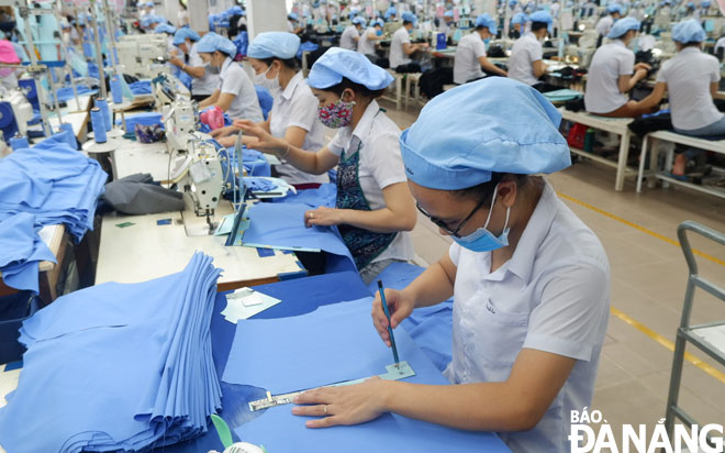 Supporting businesses to restore and develop production is hailed as an important solution to fulfill budget collection tasks. In the photo are dedicated workers at the Da Nang-based 23 March Textiles JSC