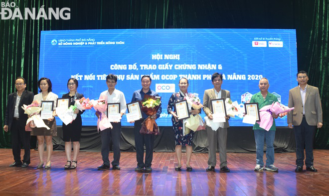 Da Nang People’s Committee Vice Chairman Ho Ky Minh (right) and owners of manufacturing establishments whose their products meet 4-star standards under the so-called OCOP model