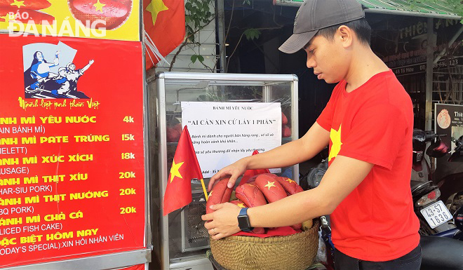 Anh Nguyễn Văn Hòa bổ sung thêm bánh mỳ để tặng miễn phí cho người lao động nghèo. Ảnh: L.P