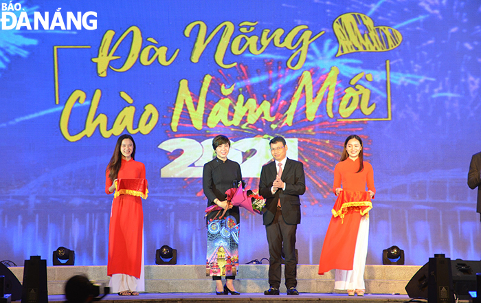 Municipal People’s Committee Vice Chairman Ho Ky Minh (2nd right) presenting a souvenir medal to the festival’s sponsor