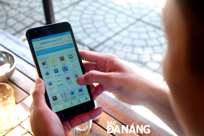 Thành phố đang thí điểm ứng dụng tích hợp đa dịch vụ của nhiều ứng dụng (Danang Smart city) để người dân, doanh nghiệp tiện cài đặt và sử dụng trên điện thoại thông minh. Trong ảnh: Người dân cài đặt và sử dụng ứng dụng Danang Smart city. Ảnh: TRỌNG HUY