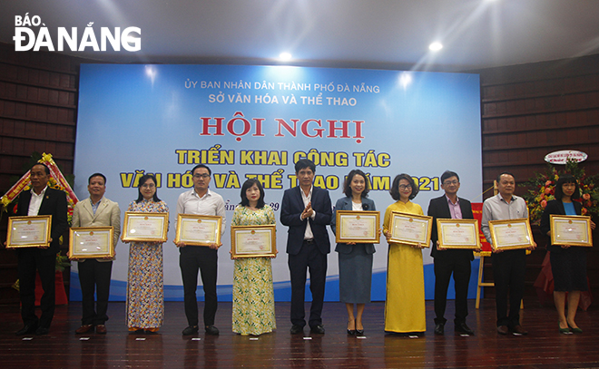 Giám đốc Sở Văn hóa và Thể thao thành phố Huỳnh Văn Hùng trao bằng khen của Chủ tịch UBND thành phố cho các tập thể, cá nhân tại hội nghị. Ảnh: XUÂN DŨNG