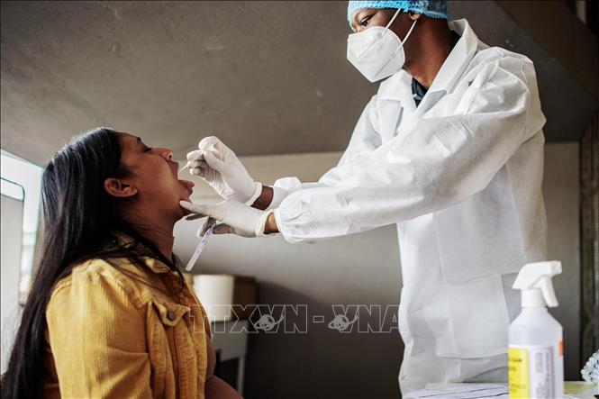 Nhân viên y tế lấy mẫu dịch xét nghiệm COVID-19 cho người dân tại Richmond, Johannesburg, Nam Phi, ngày 18/12. Ảnh: AFP/TTXVN